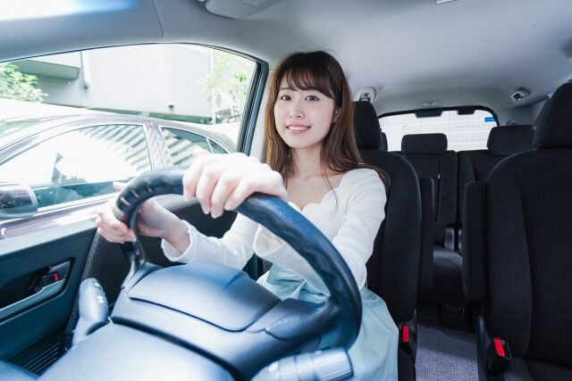 笑顔でハンドルを握る女性ドライバー