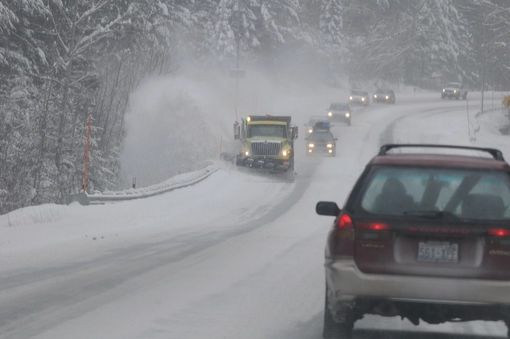 雪の降る道路を走る車